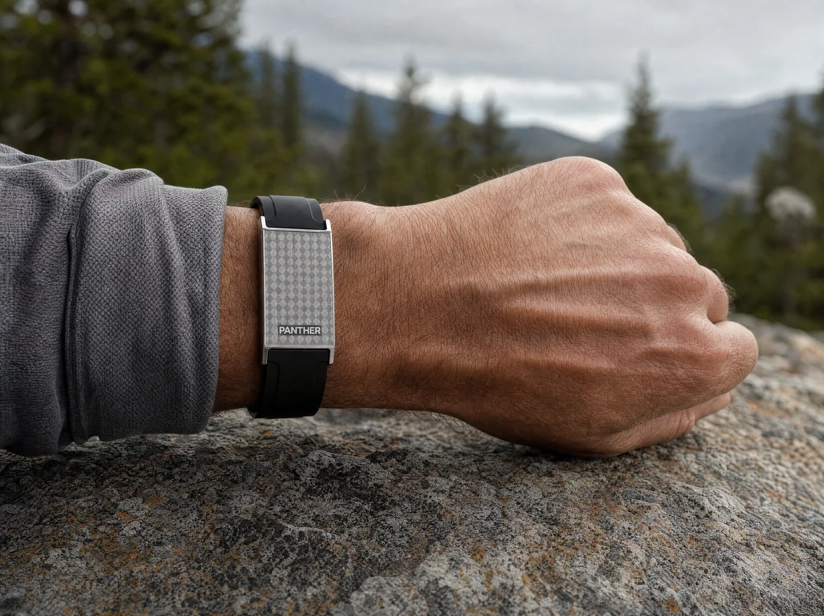 Panther Eclipse worn on the wrist during a mountain trail hike, showing active fitness tracking in a premium design